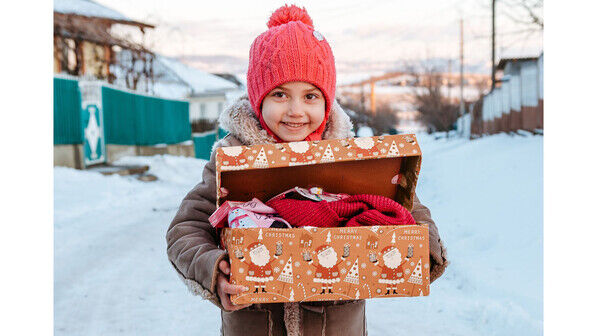 Strahlende Augen: Dieses Mädchen aus Moldawien freut sich über ein prall gefülltes Geschenk-Päckchen der Aktion „Weihnachten im Schuhkarton“.