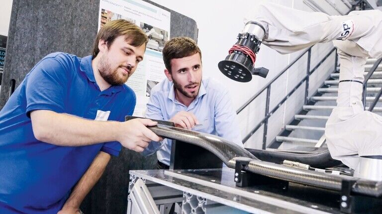 Probelauf: Sebastian Backes (rechts) und Sascha Jungblut mit einem neuartigen Schleifroboter – etwa für Hightech-Carbonflügel von Autos, wie hier zu sehen.