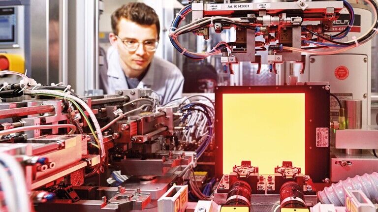 Produktionsingenieur Klaus Lohmann inspiziert die Fertigungslinie für Regen-Licht-Sensoren: Hier konnten die Bremer HFK-Ingenieure den Scheinausfall in der Fertigung mithilfe von KI um 99 Prozent senken.