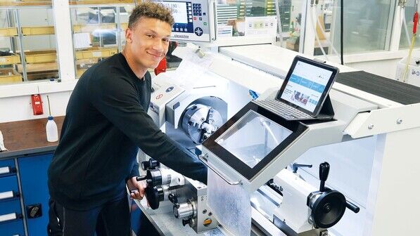 Hat sein Tablet immer griffbereit: Der Industriemechaniker-Azubi Tom Rustler an der Drehmaschine in der Ausbildungswerkstatt von ZEISS SMT in Wetzlar.