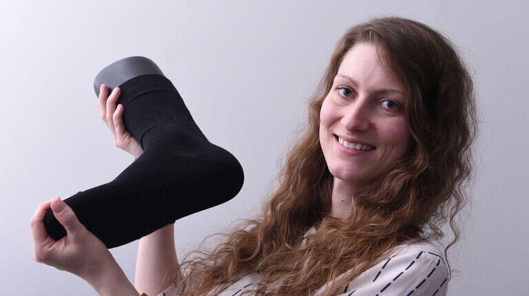 Made with Kohlendioxid: Ricarda Wissel mit einer Socke, in der das spezielle Garn verstrickt ist.