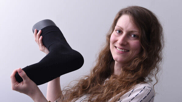 Made with Kohlendioxid: Ricarda Wissel mit einer Socke, in der das spezielle Garn verstrickt ist.