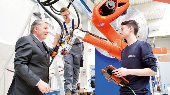 An einer Anlage für Baumaschinen: Sieghard Thomas (CEO) Azubi David Heuser und Roboterprogrammierer Tim Brachthäuser