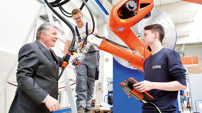 An einer Anlage für Baumaschinen: Sieghard Thomas (CEO)
Azubi David Heuser und Roboterprogrammierer Tim Brachthäuser