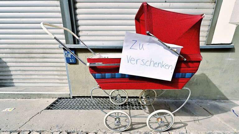 Kinderwagen auf dem Bürgersteig: Alles Mögliche wird gratis abgegeben. 