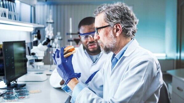 Geschmackstest im Labor: Ein Forscher probiert einen Burger aus kultiviertem Hühnchenfleisch.