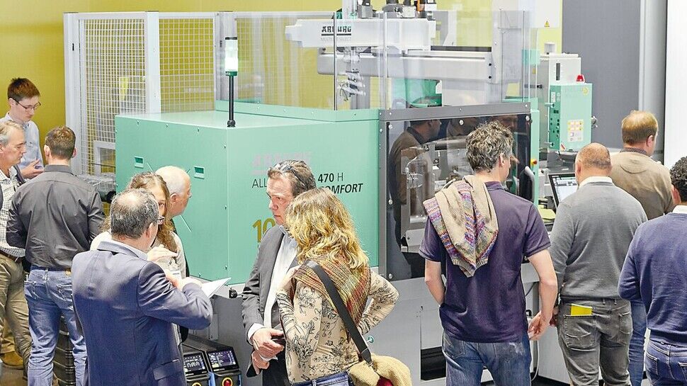 Spritzguss-Star: Diese Maschine von Arburg verbraucht dank ihrer speziellen hybriden Technik bis zu 50 Prozent weniger Energie als andere Maschinen für Kunststoff-Teile. Zu sehen sind hier Kunden bei einer Veranstaltung im Betrieb. 