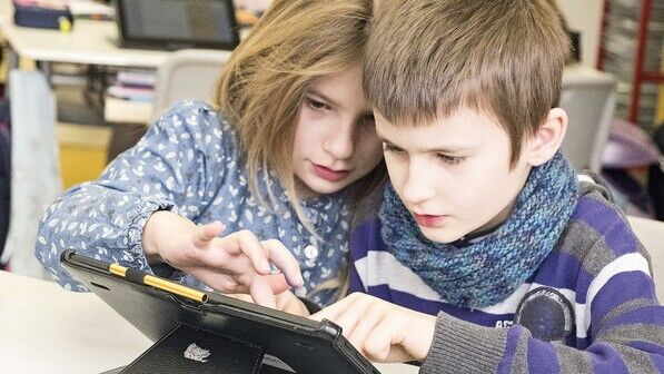 Seltenheit: Junge Schüler mit Tablet-Rechner.
