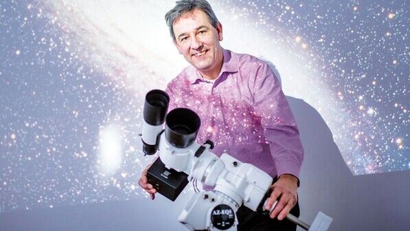 Stern-Stunden: Fotograf Holger Manz vor der Wandprojektion eines Fotos, das die Andromeda-Galaxie zeigt.