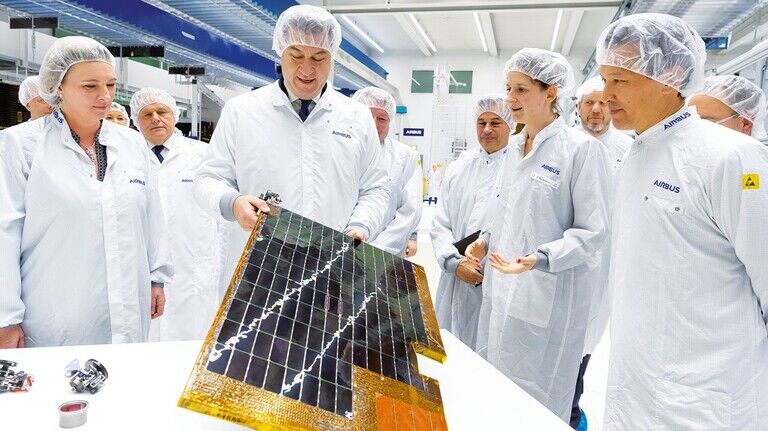 Hoher Besuch: Ministerpräsident Markus Söder begutachtet ein Solarpanel im Reinraum von Airbus.